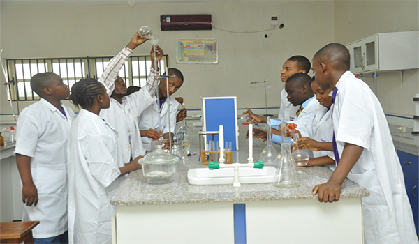 Best secondary school in Lagos State science lab with students performing experiments”